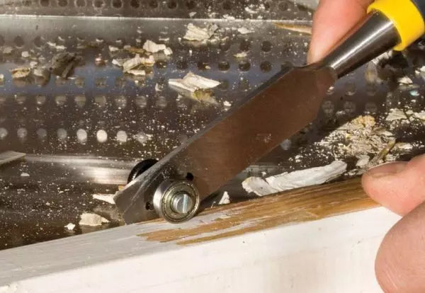 putty chisel removing old glazing putty from wooden window frame